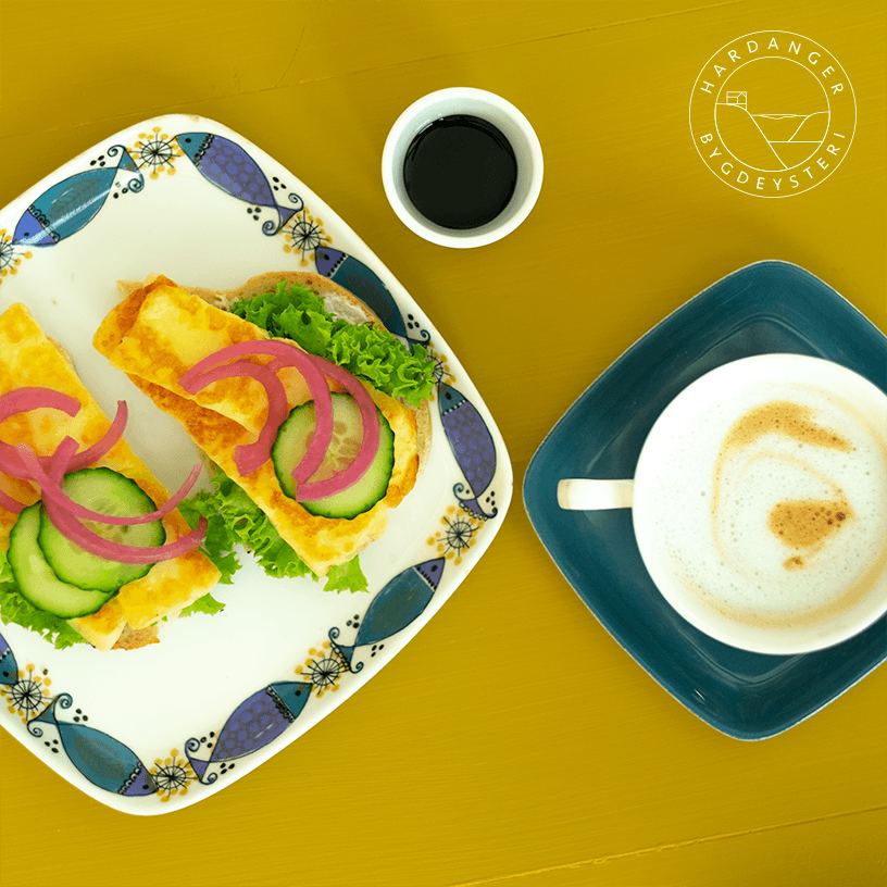 Steikeost på brød med sylta raudløk, med kaffi ved sida